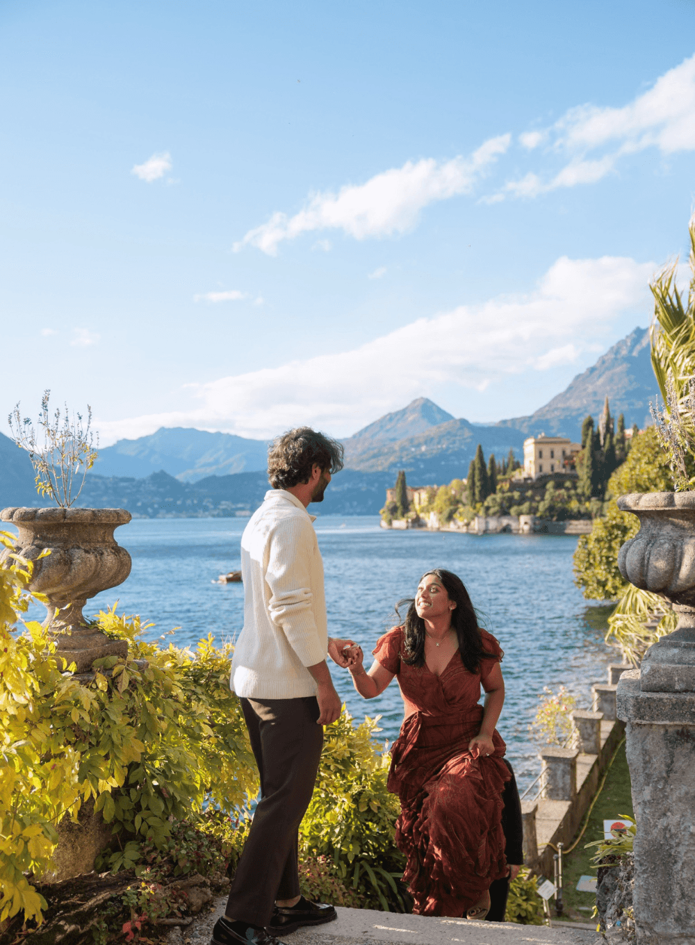 Esha & Anish at the moment of the proposal on a staircase above Lake Como